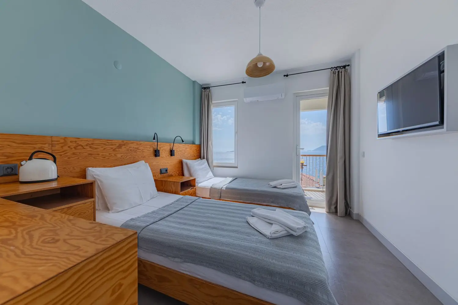 Vaalea kahden hengen hotellihuone puukalusteilla
