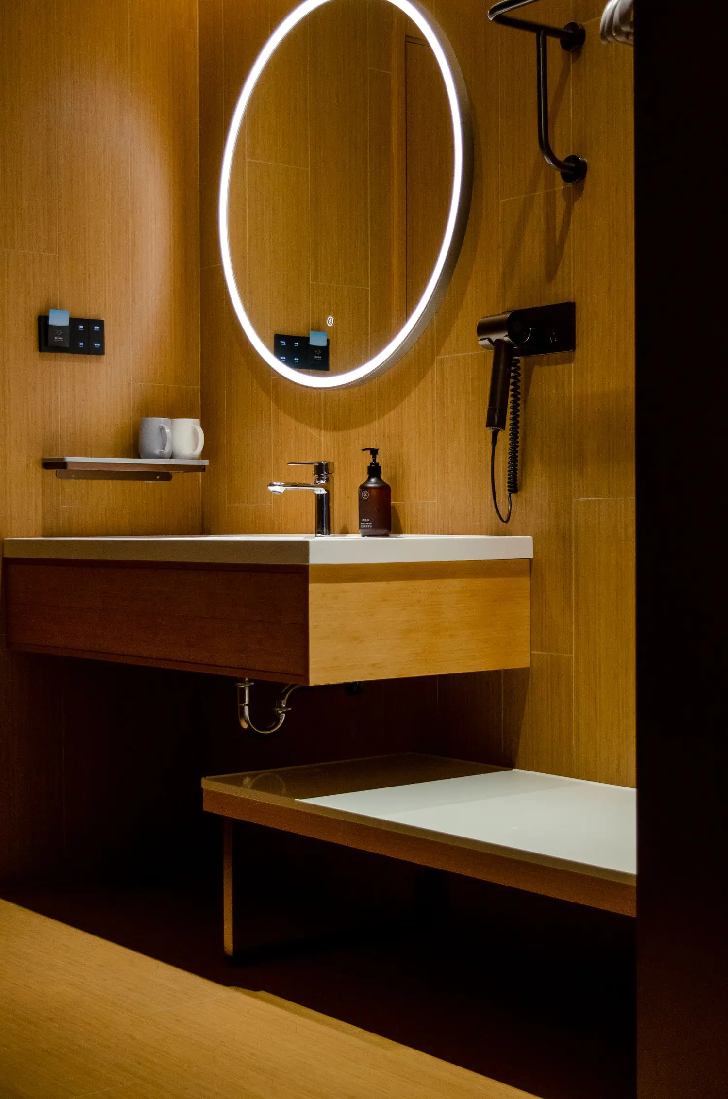 Hotellihuoneen valaistu peili ja pesuallas