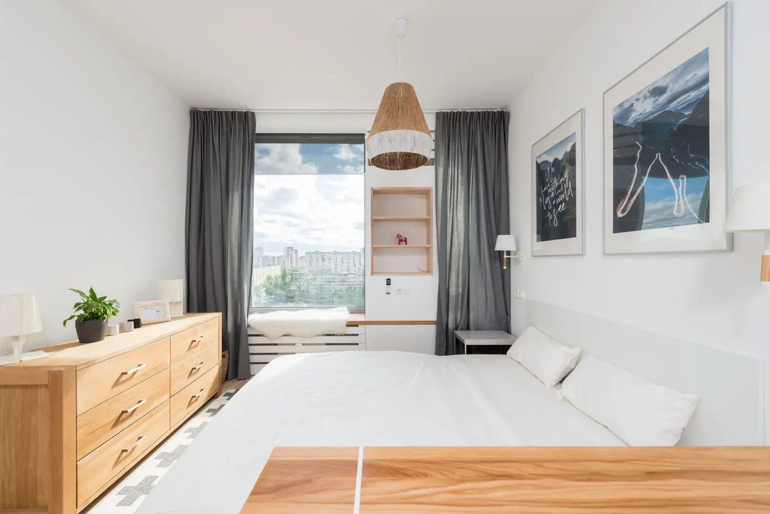 Vaalea hotellihuone, jossa on sohva ja puupintoja
